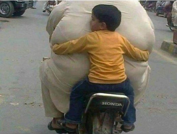 Boy Holding Fat Man In Arms
